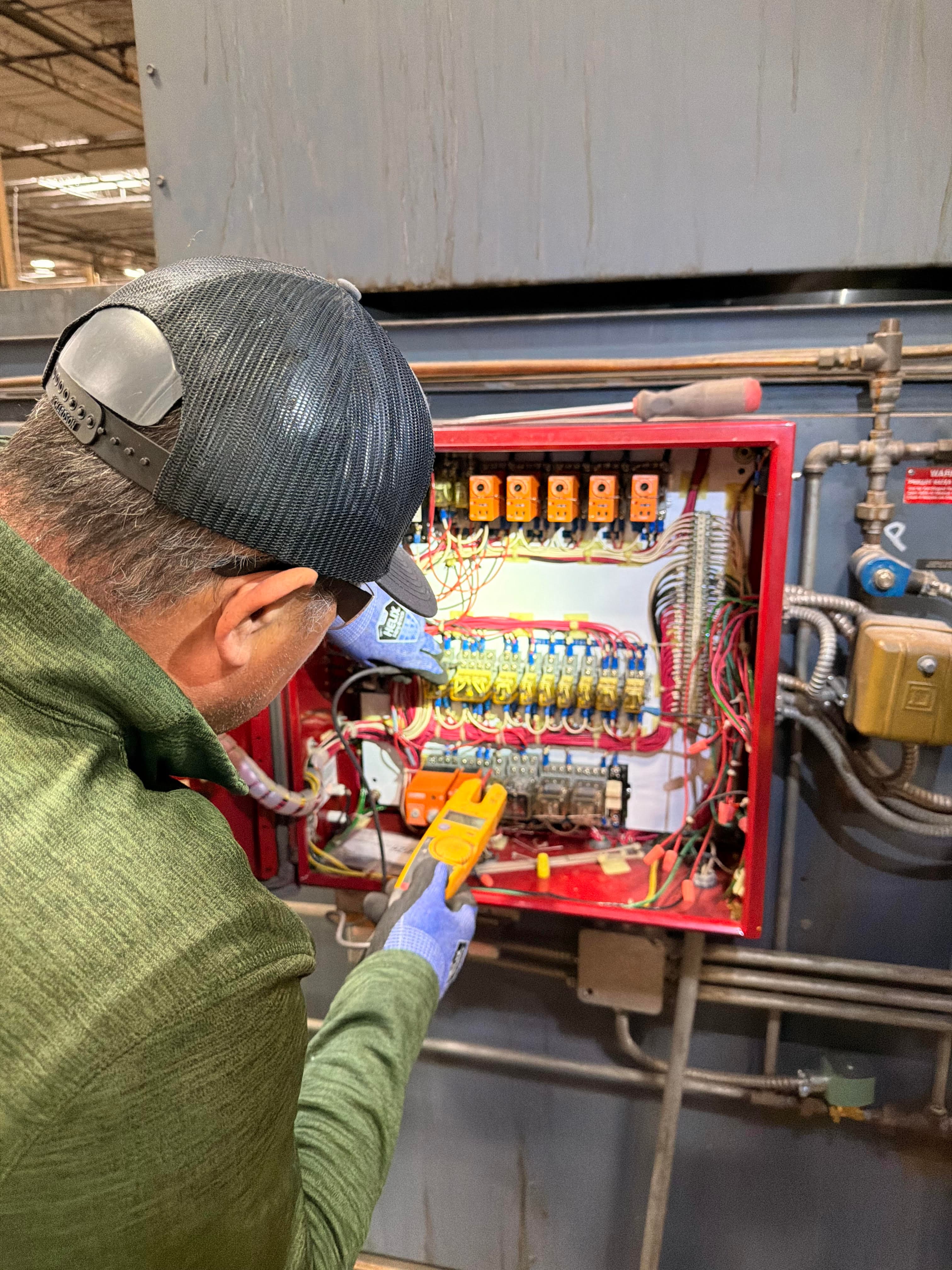 Technician performing diagnostic troubleshooting on burn-off oven